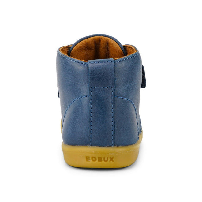 The Bobux Iwalk IW Desert Boot Midnight Blue 625217 is a vintage-style children’s leather boot in blue with a tan sole, brown interior lining, and the BOBUX name embossed on the sole, shown from the back., 9420068516984, 9420068516991, 9420068517004, 9420068517011, 9420068517028