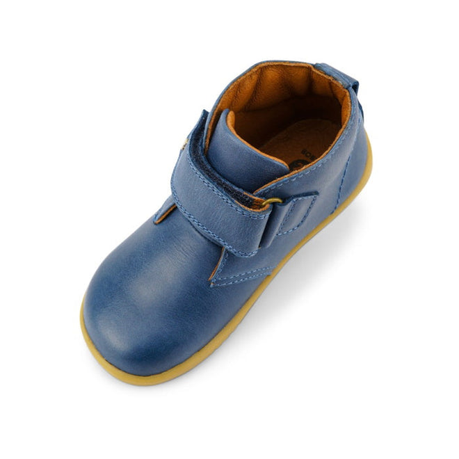 A single Bobux Iwalk IW Desert Boot Midnight Blue 625217, featuring a yellow sole, brown inner lining, and wide strap closure for easy fastening, is viewed from above on a white background., 9420068516984, 9420068516991, 9420068517004, 9420068517011, 9420068517028