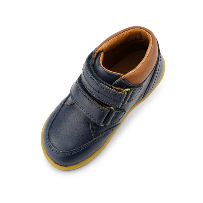 The Bobux Iwalk Timber Navy Leather Boot 632619 is a single unisex kids' boot in dark blue leather with a tan lining, yellow sole, and two adjustable straps, shown from above on a white background., 9420068529298, 9420068529304, 9420068529311, 9420068529328, 9420068529335