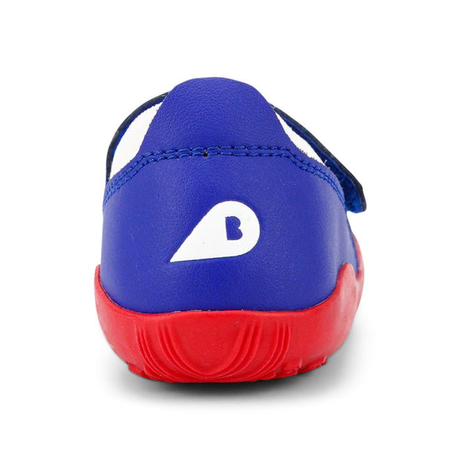 A rear view of the Bobux Step Up SU Dimension III Blueberry First Walker shows a blue upper, red sole, and white stylized B logo on the heel, plus toe protection for active kids., 9420068533042, 9420068533059, 9420068533066, 9420068533073