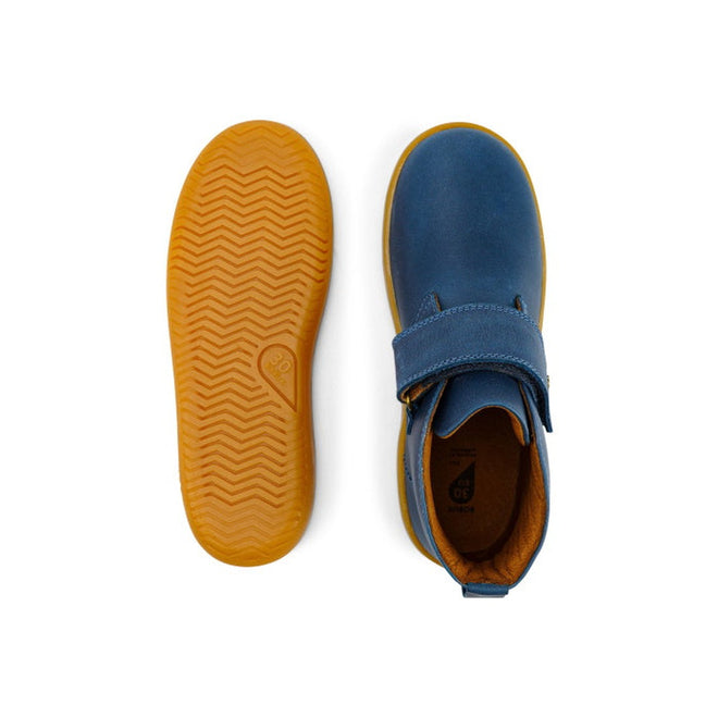 The Bobux Kid+ Desert Boot Midnight Blue 830312 is a pair of children's blue high tops with brown soles. One shoe showcases the wide velcro opening from above, while the other displays the textured herringbone-patterned sole., 9420068517035, 9420068517042, 9420068517059, 9420068517066, 19835, 19836, 19837