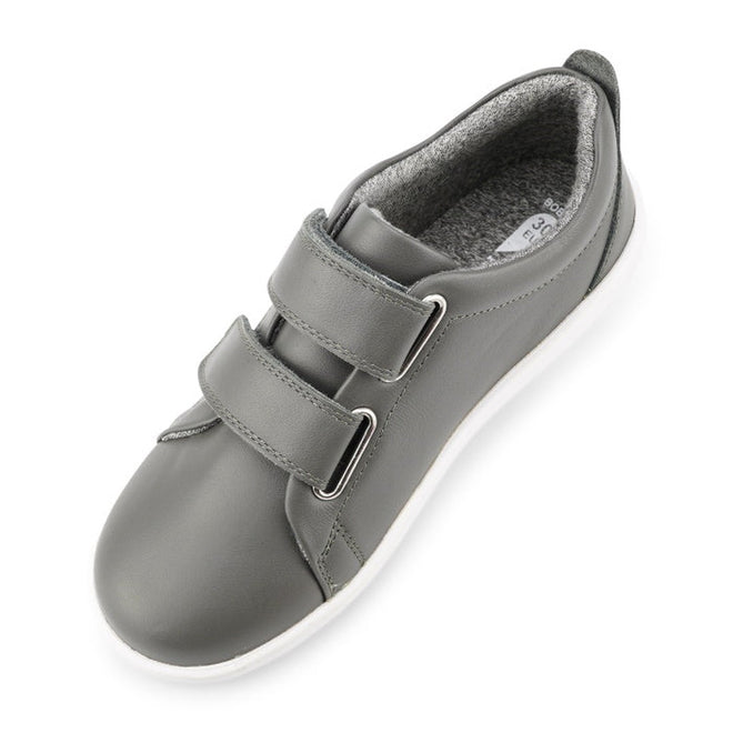 The Bobux Kids + Plus Grass Court Smoke Grey Velcro Trainers 832446 feature a gray leather upper, white sole, two adjustable Velcro straps, and soft padded lining—ideal everyday street shoes for kids' comfort., 9420068518025, 9420068518032, 9420068518049, 9420068518056, 9420068518063, 9420068518070, 9420068518087