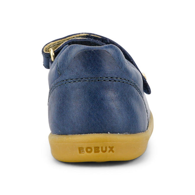 The Bobux Iwalk Delight Mary Jane Midnight Blue 628048 is a children’s shoe with blue leather, a tan rubber sole embossed with “BOBUX” on the heel, and a secure velcro strap over the upper, shown from the back., 9420068516748, 9420068516755, 9420068516762, 9420068516779, 9420068516786