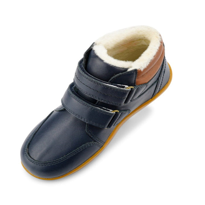 The Bobux Kid+ Timber Arctic WATERPROOF Boot Navy 836003E is shown from an angled top view, featuring two Velcro straps, a brown heel accent, rubber sole, and soft white fleece lining against a white background., 9420068529489, 9420068529496, 9420068529502, 9420068529519, 9420068529526, 9420068529533, 9420068529540