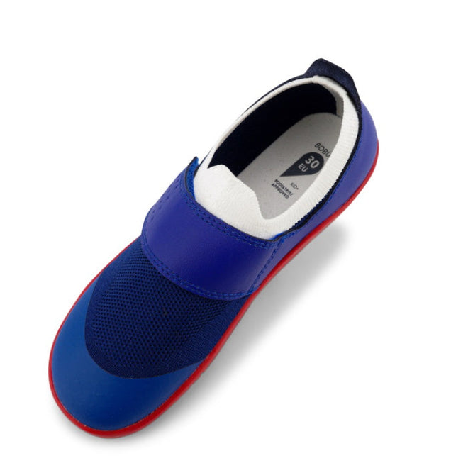 A single Bobux Kid+ Lo Dimension III Blueberry 838605 slip-on shoe features a blue mesh toe, red sole, black accents, elastic band for flexibility, and white inner lining with a visible size label., 9420068533134, 9420068533097, 9420068533080, 9420068533103, 9420068533110, 9420068533127, 9420068533141