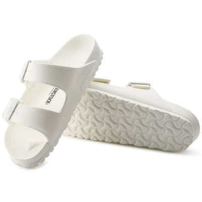 a pair of Birkenstock Arizona EVA White Narrow Width with double straps, one over the foot and one over the toes with buckle adjustment. Staps are linked at the sides of the foot. Made of EVA a plastic like material, suitable fot being around water