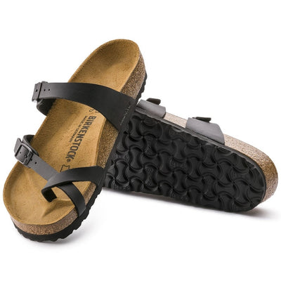a pair of Birkenstock Mayari Womens Birko Flor Black Regular Width- thin strappy sandals with bubkle adjustment over the foot and on the outside of the foot near the toe area. Straps cross cross over the toes and a separate strap over the top of the foot. Suede foot bed with arch support. Mostly a women's styel