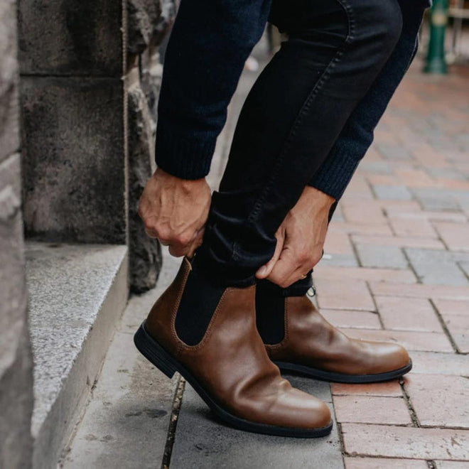 A man on a city street bending down and pulling on the blundstone 1900 dress boot in brown.
9315891500036,
9315891500050,
9315891500074,
9315891500098,, 10430, 10431, 10432, 10433, 9315891500036, 9315891500050, 9315891500074, 9315891500098
