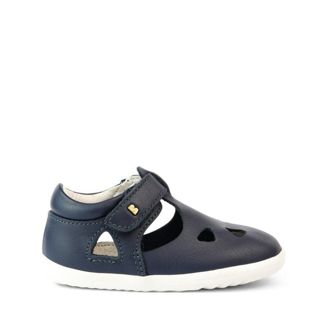 A Bobux Step Up Zap II Navy Closed Toe Sandal 732404 Quick Dry, made from quick-drying leather with a closed-toe, cut-out shapes, white sole, hook-and-loop strap and a small yellow heart, is shown against a plain white background., 9420068505476, 9420068505483, 9420068505490, 9420068505469
