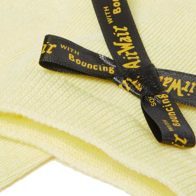 A close-up of a folded, pale yellow towel with a black ribbon tied in a bow reads "AirMail with Bouncing." Pairs well with Dr Martens Ankle Bow Cotton Blend Socks Lemon and is fully machine washable., 190665558562, 190665558555
