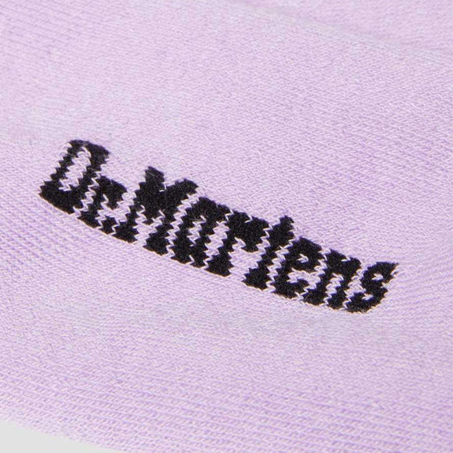 Close-up of black Dr. Martens logo embroidered on lilac cotton blend, as seen on the Dr Martens Ankle Bow Socks (Small/Medium up to UK7, Medium/Large above UK7), inspired by classic throwback sock style., 190665558609, 190665558593