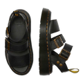 A flaylay shot of the Dr Martens Quad Gryphon Sandal in Black in Pisa Leather. A top down view of the inner sole footbed of the right foot. A side outer foot view of the left foot showing yellow stitching around the sole. 2 staps over yhe top of the foot. The higher with buckle adjustment ans the adjustable strap around the leg.,
190665318654,
190665318661,
190665318678,
190665318685,
190665318692,
190665318708,
190665318715,
