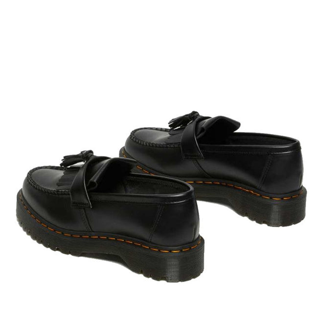 A pair of Dr Martens Adrian Bex Black Smooth Platform Loafer Shoes with tassels, thick grooved soles, and yellow Goodyear-welt stitching, shown from the back and side on a white background., 183681, 190665420241, 190665420166, 190665420173, 190665420180, 190665420197, 190665420203, 190665420210, 190665420227