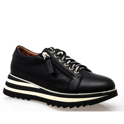 The Alfie & Evie Hosting Womens Leather Shoe Platform Black features a smooth black leather finish, thick striped black-and-white platform sole, black laces with white accents, and a stylish side zipper.