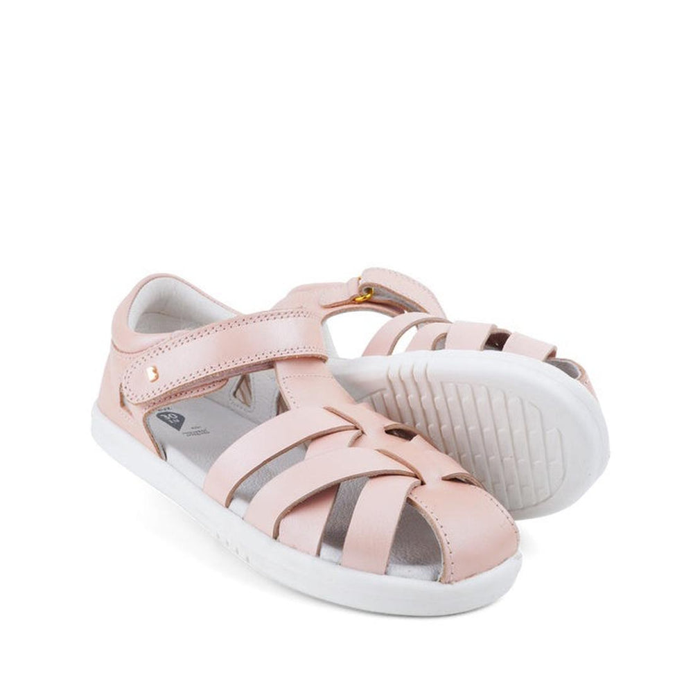A pair of Bobux Kids Plus KP Tropicana II Seashell Shimmer Quick Dry Sandals (style 838305) for children, featuring a light pink hue with white soles and Velcro straps, expertly crafted from Quick Dry Leather—ideal as kids’ summer shoes—displayed against a white background.