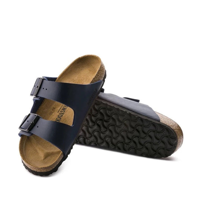 a pair of Birkenstock Arizona Birko Flor Blue Regular Width with double straps, one over the foot and one over the toes with buckle adjustment. Staps are linked at the sides of the foot. Synthetic straps and a suede leather footbed,