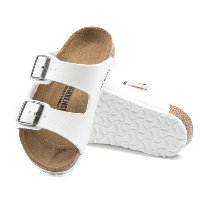 a pair of Birkenstock Kids Arizona White Birko Flor Narrow with double straps, one over the foot and one over the toes with buckle adjustment. Staps are linked at the sides of the foot. Synthetic straps and a suede leather footbed,