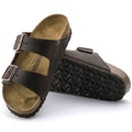 a pair of Birkenstock Arizona Oiled Leather Leather Habana Brown Regular Width with double straps, one over the foot and one over the toes with buckle adjustment. Staps are linked at the sides of the foot. Leather thick straps and a suede leather footbed,