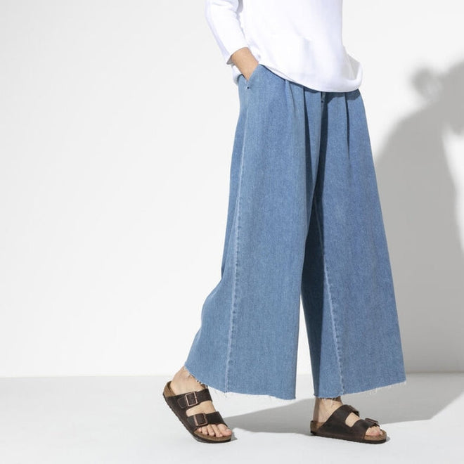 A shot of a models legs & feet weraing light blue denium wide leg jeans with Birkenstocks Habana Arizona Slide in narrow width. Shows both feet the outer side of the right foot and inner side of the left foot. Showing the 2 straps and buckle detailing.,
4040714437545,4040714437521,4040714437538,4040714437552,4040714437569,4040714437576,4040714437583,4040714437590, , , , ,
