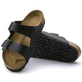 a pair of Birkenstock Arizona Birko Flor Black Narrow Width with double straps, one over the foot and one over the toes with buckle adjustment. Staps are linked at the sides of the foot. Synthetic straps and a suede leather footbed,