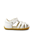 The Bobux Step Ups Cross Jump White 731106 Closed Toe Sandal features a leather upper, crisscross straps, hook-and-loop closure, and a light brown sole—ideal as a first walker. Shown on a plain white background., 9420062083901, 9420062083918, 9420062083925, 9420062083932
