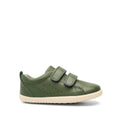 The Bobux Kids + Plus Grass Court Forest Green Velcro Trainer (832463) features double Velcro straps, side perforations, cotton knit lining, and a light beige rubber sole. The single green leather shoe is shown on a plain white background.