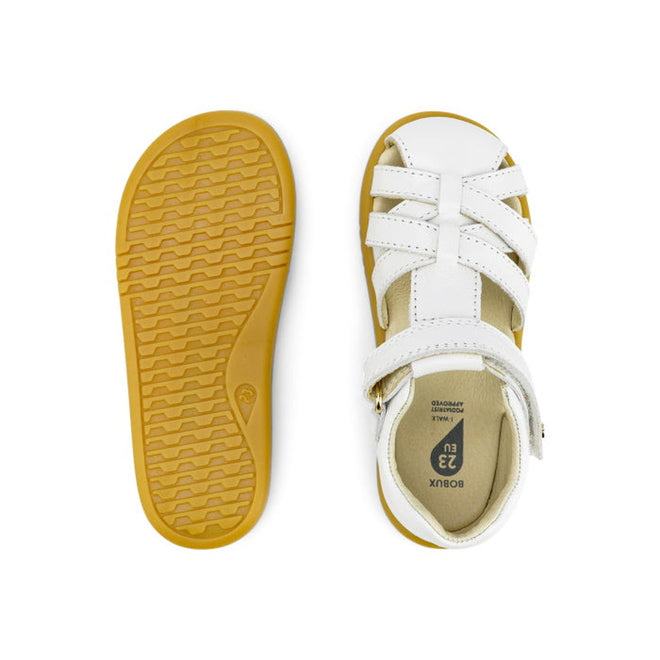 The Bobux iWalk Cross Jump Sandal White Closed Toe 636706 is shown in white leather with tan rubber soles; one sandal displays the textured sole, while the other highlights the strappy top and buckle design., 9420062083949, 9420062083956, 9420062083963, 9420062083970, 9420062083987