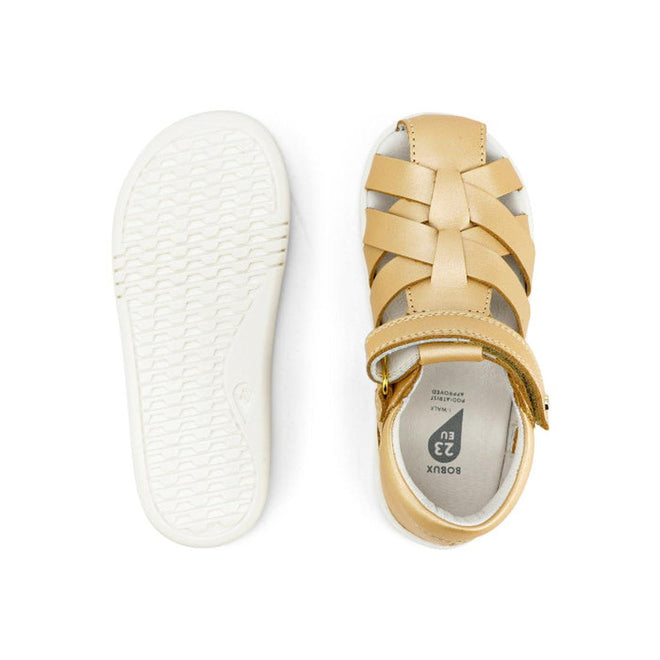 A pair of Bobux Iwalk IW Tropicana II Sandal 638311 in Pale Gold for children, shown from top and bottom, featuring a closed toe, woven Quick Dry Leather straps, hook-and-loop closure, and a white textured rubber sole., 9420068529946, 9420068529953, 9420068529960, 9420068529977, 9420068529984