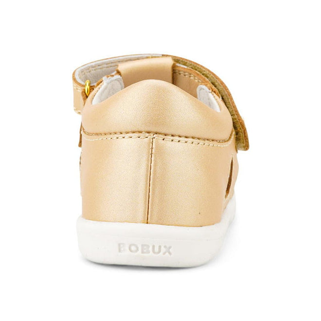 The Bobux Iwalk IW Tropicana II Sandal 638311 in Pale Gold is shown from the back, featuring a white sole, embossed BOBUX branding on the heel, and a visible Velcro strap. Made from Quick Dry Leather—ideal for active kids., 9420068529946, 9420068529953, 9420068529960, 9420068529977, 9420068529984
