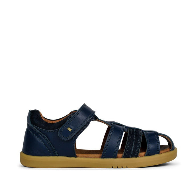 The Bobux Kid+ Plus Roam Navy Closed Toe Sandal 830503A is a stylish navy boys' sandal with leather upper, closed heel, open toe, adjustable Velcro strap, and light brown rubber sole—perfect for active kids. Shown side-on against a white background., 9420062049884, 9420062049891, 9420062049907, 9420062049914, 9420062049921, 9420062049938, 9420062049945