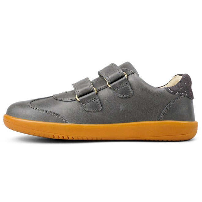 The Bobux Kids Plus KP Sprite Sneaker Charcoal Grey, from the winter 2023 collection, features two Velcro straps and a yellow-orange textured sole. Shown in left profile against a white background, these unisex shoes combine style, comfort, and durability., 9420071316724, 9420071316731, 9420071316748, 9420071316755, 28331, 28332, 28333