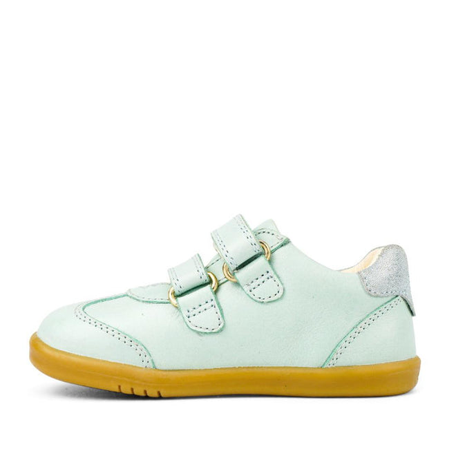The Bobux Kids IWalk IW Sprite Sneaker in Mist Blue is a unisex shoe featuring double straps, a yellow-brown rubber sole, and a metallic silver heel patch, displayed in side view on a white background., 9420071311095, 9420071311101, 9420071311118, 9420071311125, 9420071311132