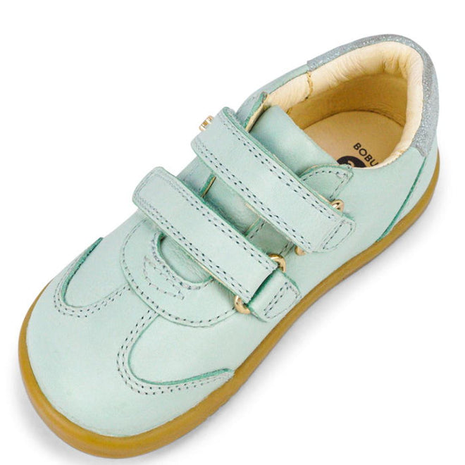 The Bobux Kids IWalk IW Sprite Sneaker in Mist Blue features double strap closures, a beige interior lining, and a light brown rubber sole, displayed at an angle., 9420071311095, 9420071311101, 9420071311118, 9420071311125, 9420071311132