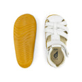 The Bobux Step Ups Cross Jump White 731106 Closed Toe Sandal features white leather straps, a tan rubber sole, and a kids-first walker design; one sandal is shown from the top while the other displays its textured sole., 9420062083901, 9420062083918, 9420062083925, 9420062083932