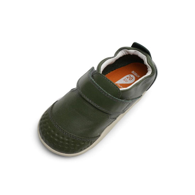 The Bobux Xplorer Go Forest Green First Walker 501038 is a single toddler shoe in olive green, featuring a Velcro strap, flexible sole, textured toe, and an orange size label (20 EU) inside. Ideal for first steps., 9420071319084, 9420071319091, 9420071319107, 9420071319077