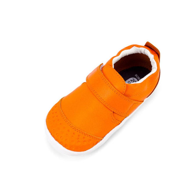 The Bobux Xplorer Go Tangelo First Walker 501035 is an orange toddler shoe with a textured toe, white flexible sole, and soft leather Velcro strap—ideal for first steps and shown on a white background., 9420071309429, 9420071309436, 9420071309443