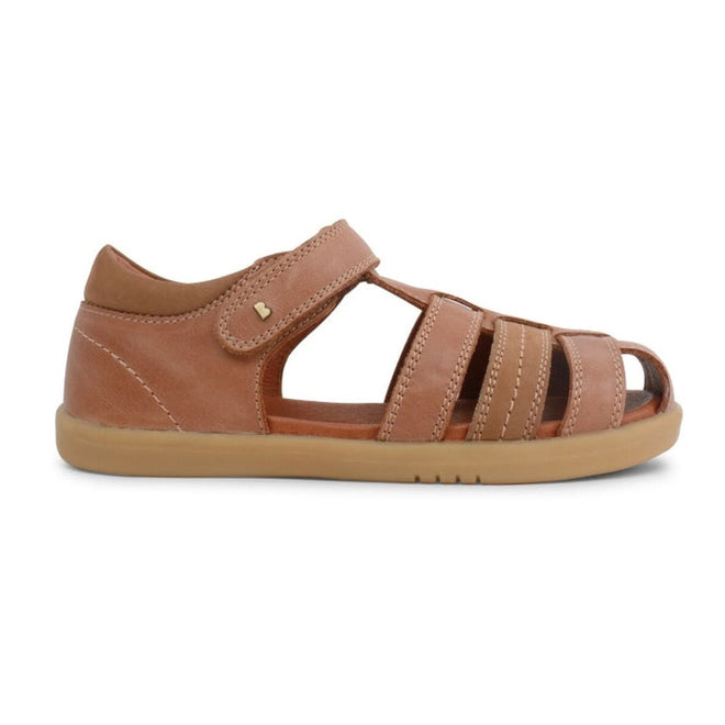 The Bobux Kid+ Plus Roam Caramel Closed Toe Sandal (830506A) for boys features a brown leather design with a closed heel, open toe, multiple straps, hook-and-loop closure, and light brown rubber sole, shown side-on against a white background., 9420062049952, 9420062049969, 9420062049976, 9420062049983, 9420062049990, 9420062050002, 9420062050019