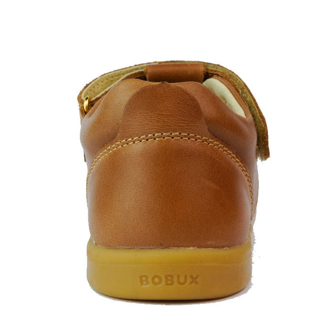A close-up rear view of the Bobux Kids Plus KP Louise Caramel Tan T-Bar shoe shows its brown leather, rubber sole, embossed BOBUX branding on the heel, visible stitching, and closed back for a timeless kids’ style., 9420068521483, 9420068521490, 9420068521506, 9420068521513, 9420075719293, 9420075719309, 9420075719316