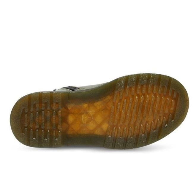 The image shows the sole of the Dr. Martens kids - 1460 J Juniors Leather Boot w/zip Khaki, featuring translucent amber rubber with a ridged tread, multiple horizontal grooves, a textured surface, and Goodyear-welted construction for durability., 27368, 27369, 190665488746, 190665488753, 190665488654, 190665488678, 190665488692