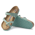 a pair of Birkenstock Mayari Womens Beryl Green Nubuck Leather Narrow Width Sandal- thin strappy sandals with bubkle adjustment over the foot and on the outside of the foot near the toe area. Straps cross cross over the toes and a separate strap over the top of the foot. Suede foot bed with arch support. Mostly a women's styel
