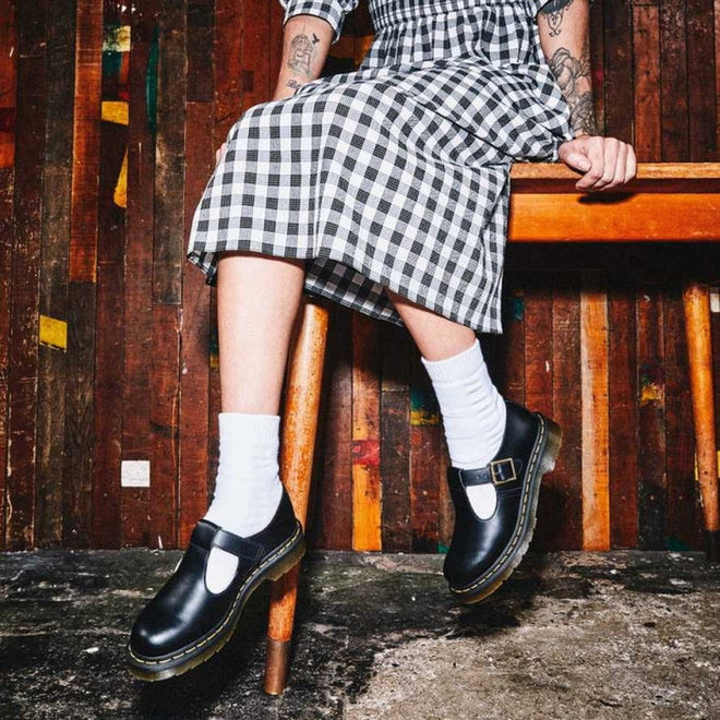 A womens in a black white ginham dress sitting on a chair and swinging her legs wearing Dr Martens Polley Mary Jane T-Bar shoes in black smooth leather. Also styling with white ankle socks.
883985498242,
883985498259,
883985498266,
883985498273,
883985498280,
883985498297,
883985498303,
883985498310,