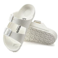 a pair of Birkenstock Kids EVA White Arizona Sandal Narrow Width with double straps, one over the foot and one over the toes with buckle adjustment. Staps are linked at the sides of the foot. Made of EVA a plastic like material, suitable fot being around water
