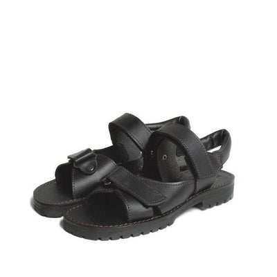 A pair of Mckinlays Safari Black School Sandals (sizes 27-34), crafted from black leather with adjustable Velcro straps and rugged soles, are positioned side by side on a white background—durable NZ-made quality, ideal for school.